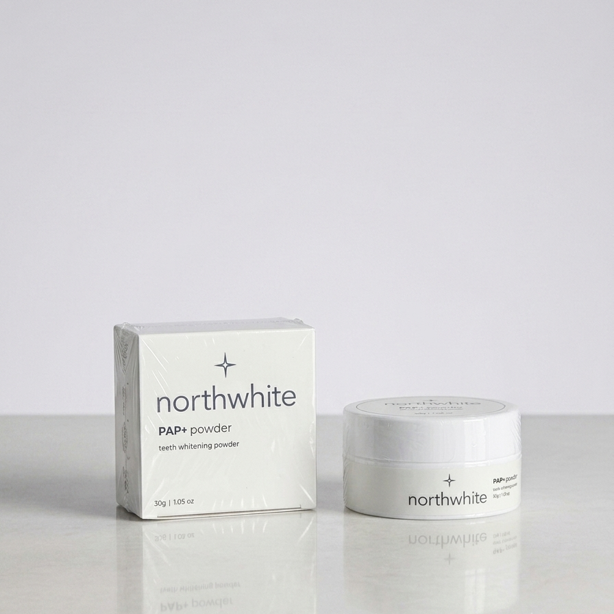 Northwhite PAPi powder teeth whitening product shown with its white box and matching white jar on a light gray reflective surface.