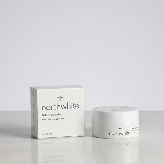 Northwhite PAPi powder teeth whitening product shown with its white box and matching white jar on a light gray reflective surface.